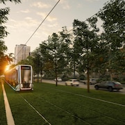 Le tramway roulant sur une bande gazonnée au centre du boulevard Laurier.