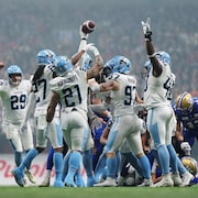 Des joueurs de football célèbrent sur le terrain. 