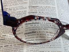 Des lunettes encadrent le mot réconciliation et réconcilier. 