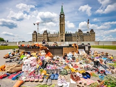 Des souliers d'enfants et des peluches près de la flamme du centenaire sur la colline du Parlement.