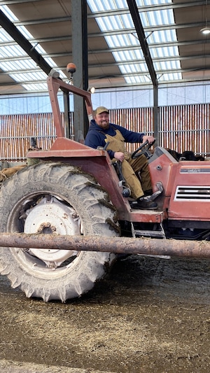 Le producteur de lait biologique Alain Lemieux nourrit ses vaches sur son tracteur à L'Isle-Verte, au Bas-Saint-Laurent.