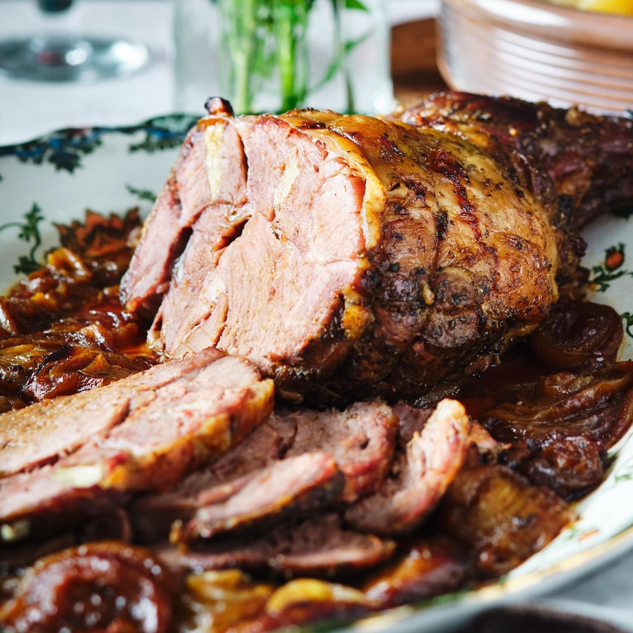 Un gigot d'agneau rôti dans une assiette de service.