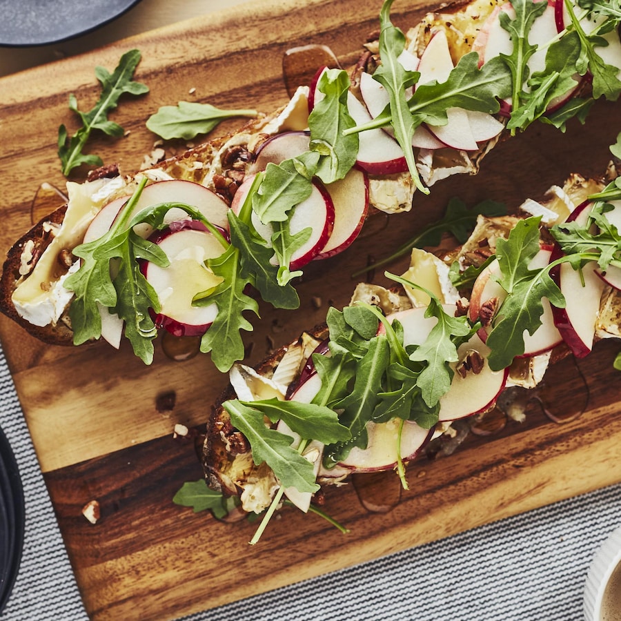 Deux baguettes garnies sont alignées sur une planche de bois.