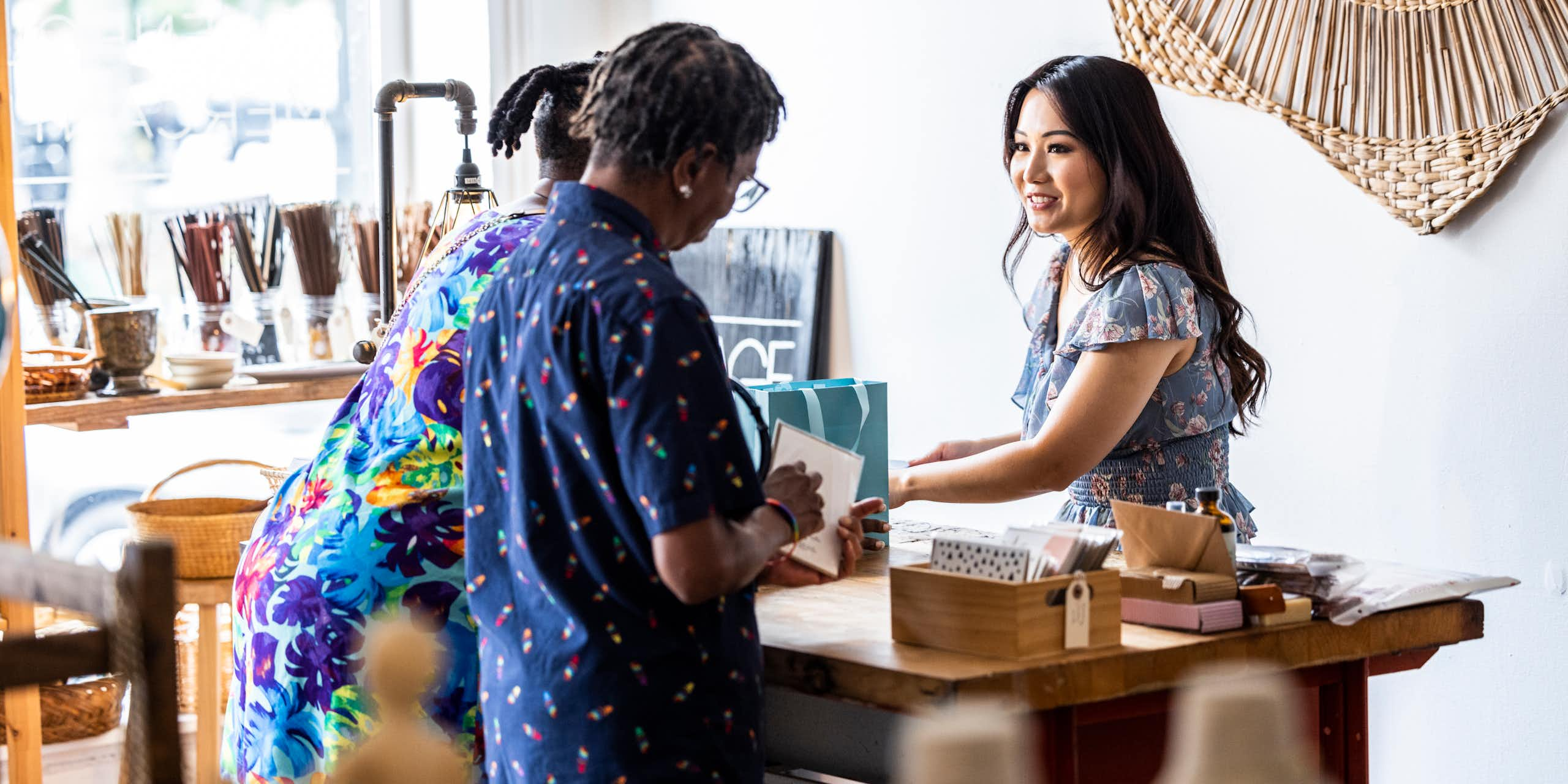  Two women are seen making a purchase at a female-owned small business.