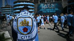 Un aficionado del Manchester City porta una bandera del equipo en frente del Etihad Stadium.