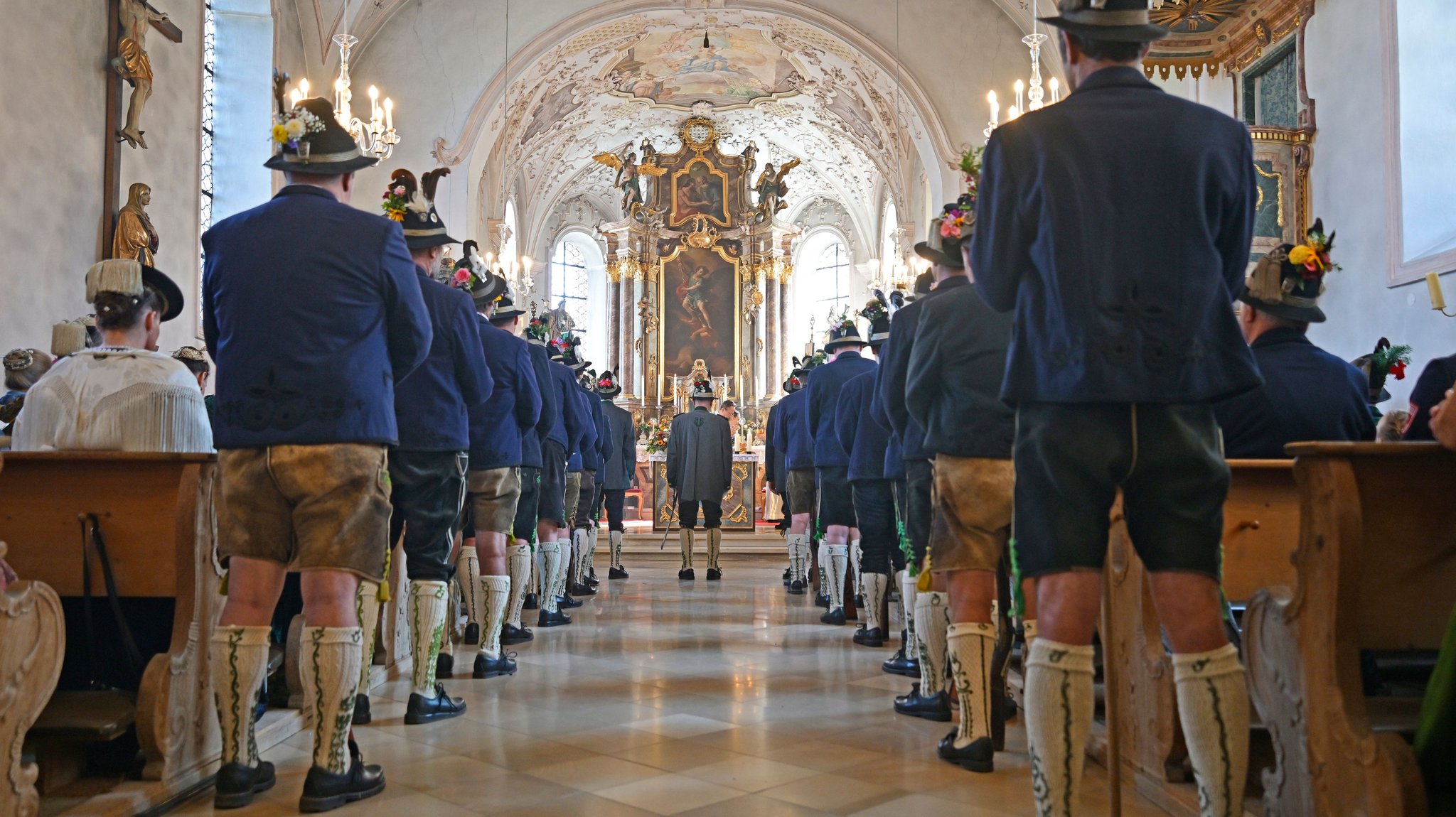 Schützen in Tracht nehmen beim jährlichen Heimattag am Kochelsee an einem katholischen Gottesdienst in der Pfarrkirche Sankt Michael teil.