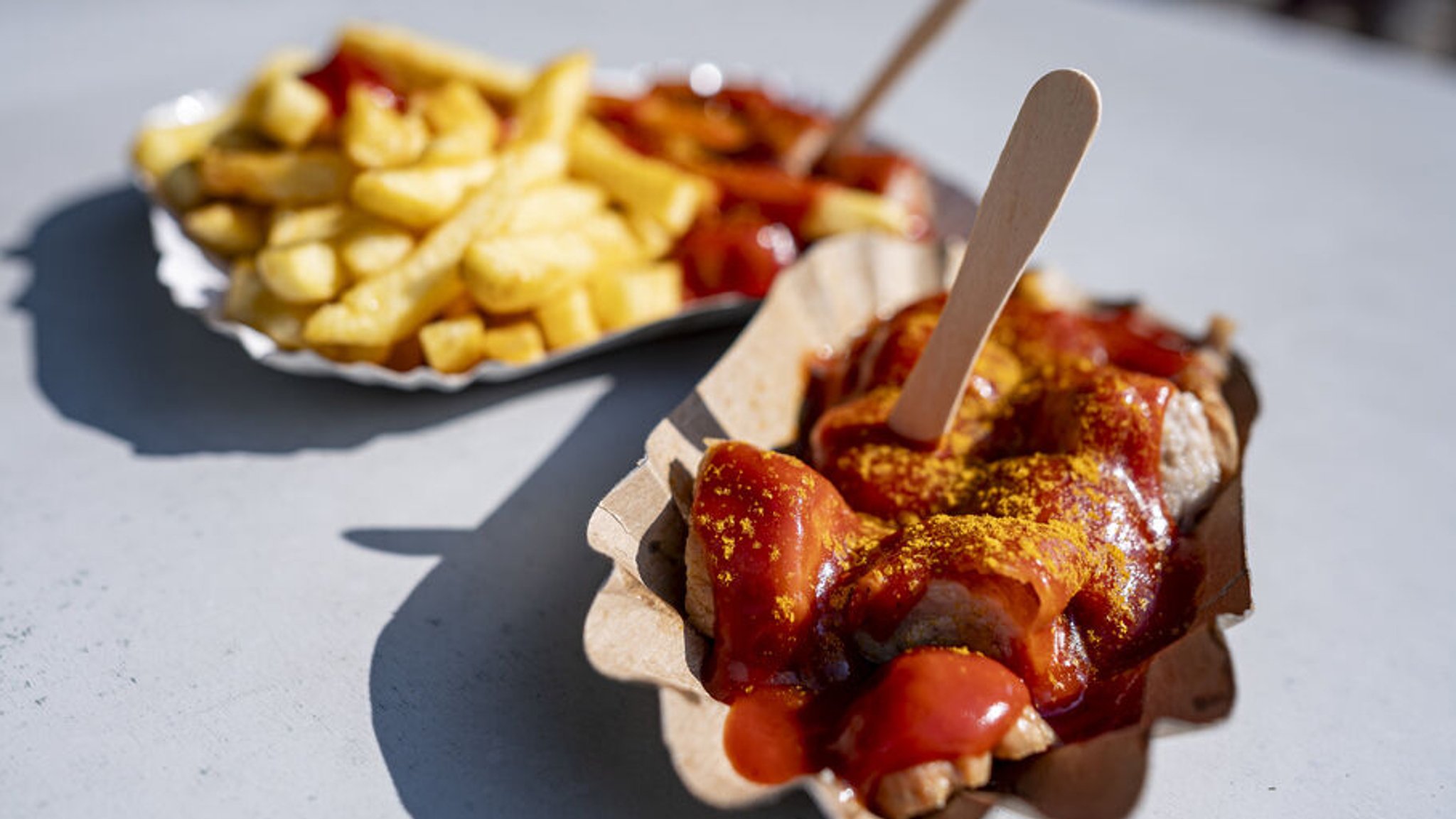 Eine Schale Currywurst steht auf einem Tisch. Der 75. Jahrestag der Erfindung der Currywurst ist am 04.09. 