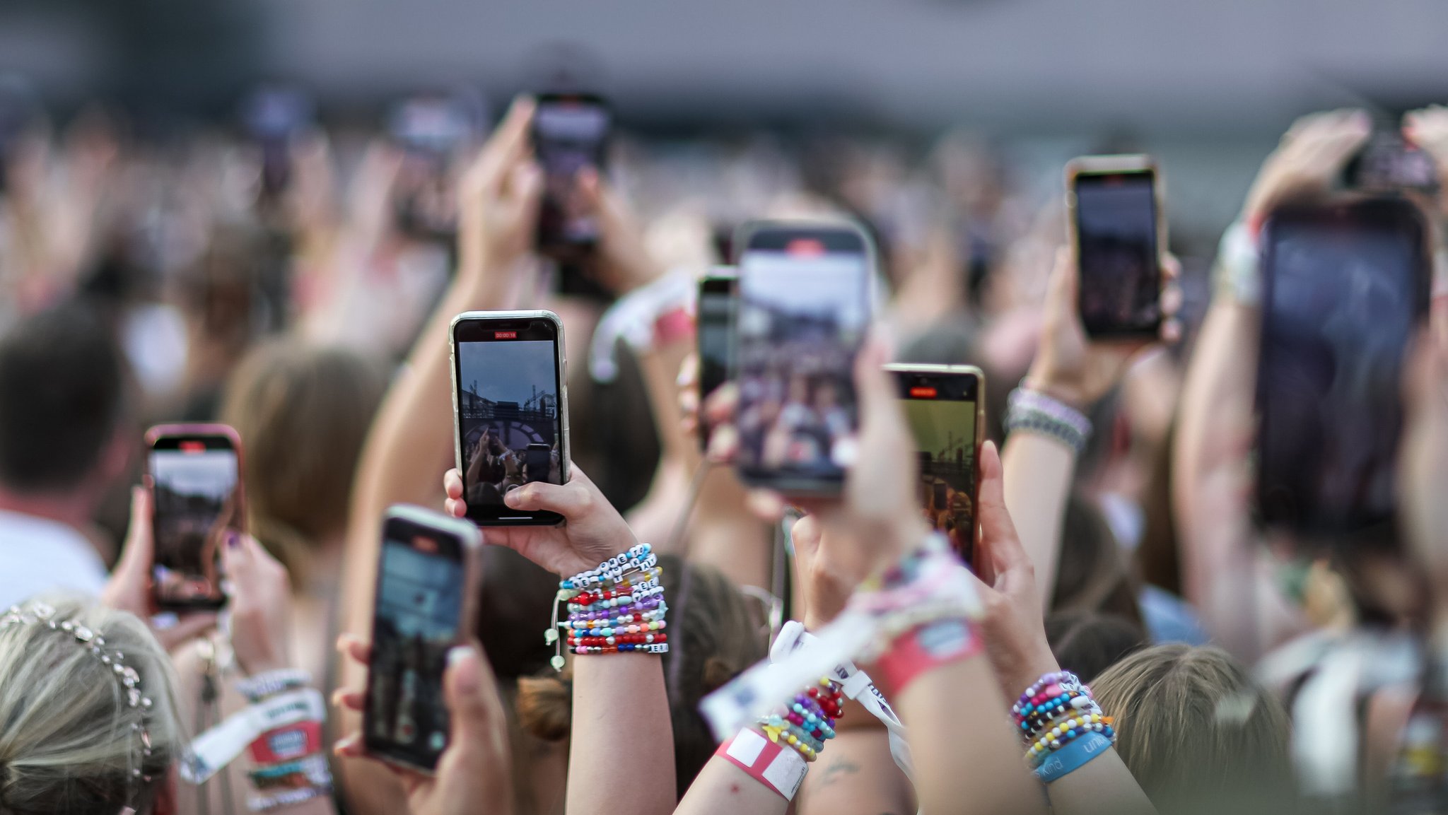 Fans halten während der Show von Taylor Swift im Münchner Olympiastadion Smartphones in die Luft.