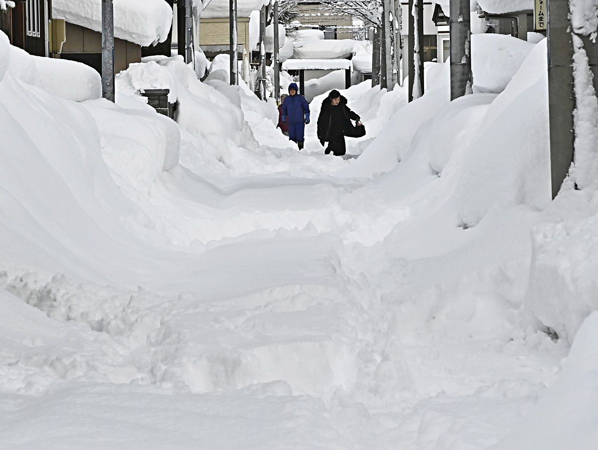 積雪が一時139センチとなった青森市。自宅前や歩道を雪かきする市民＝5日午前、同市桜川6丁目