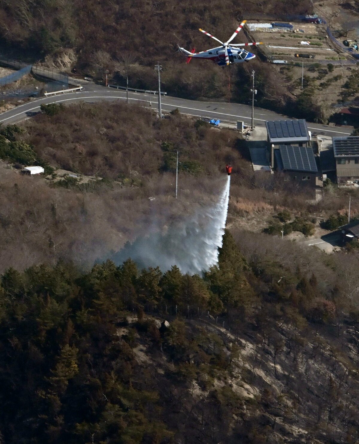 消火に当たるヘリコプター（18日午後）