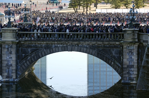 皇居の正門石橋を渡り、新年一般参賀に向かう人たち＝２日午前