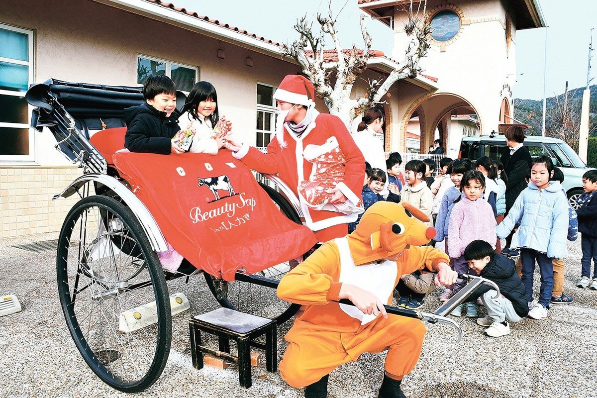 人力車に乗って、サンタクロースからプレゼントをもらう園児＝出雲市大社町杵築南、たいしゃ保育園