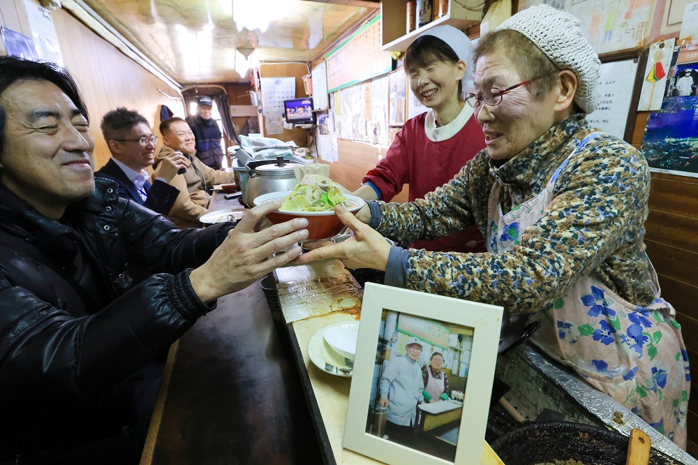 豚骨と鶏がらのＷスープが自慢のちゃんぽんを出す芳子さん（右）＝長崎市、味美食堂