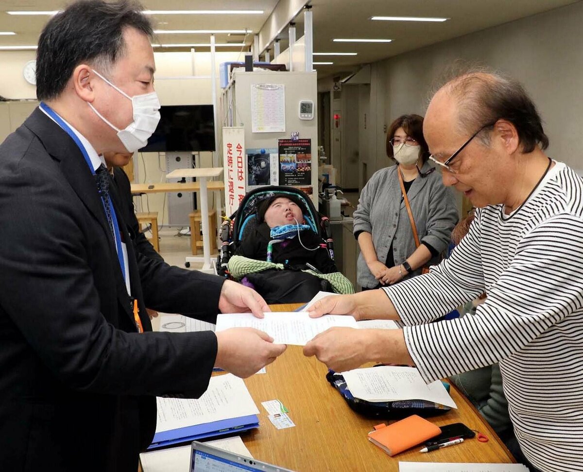 県教委職員（左端）に要請書を渡す共生連メンバーたち