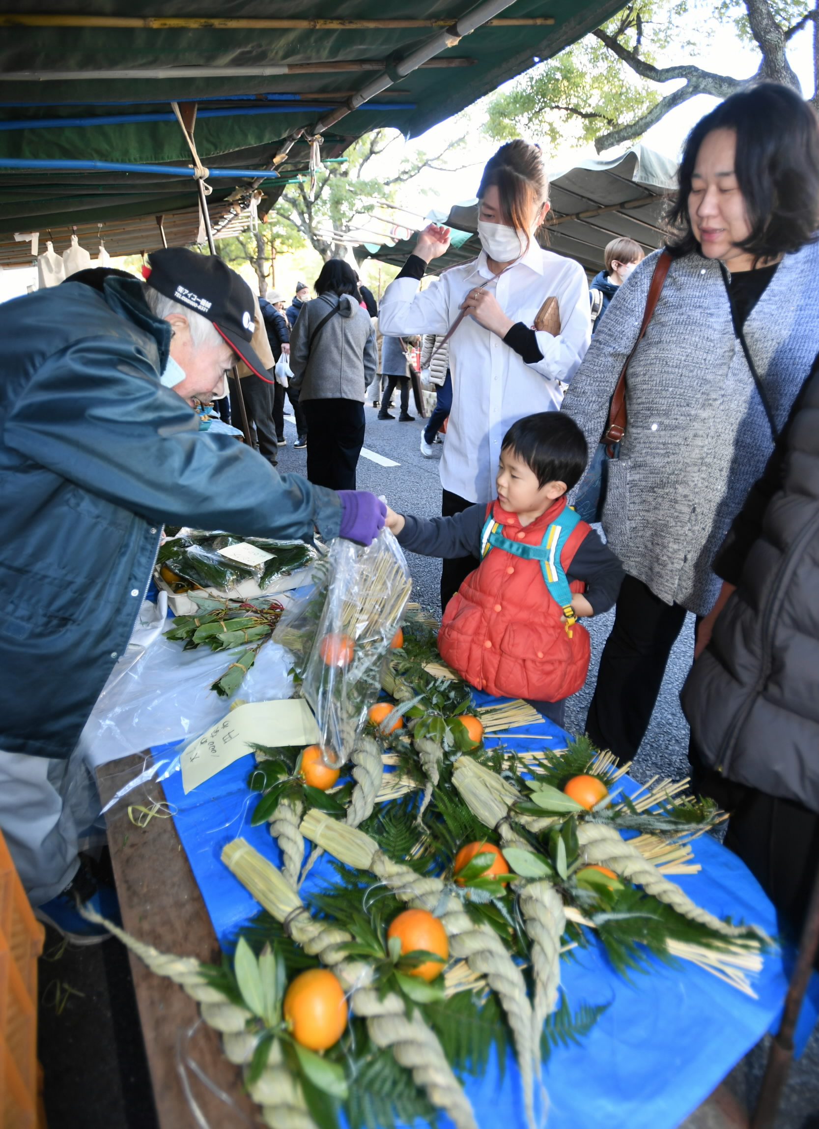 しめ縄を買い求める家族連れら（高知市追手筋2丁目＝石丸静香撮影）