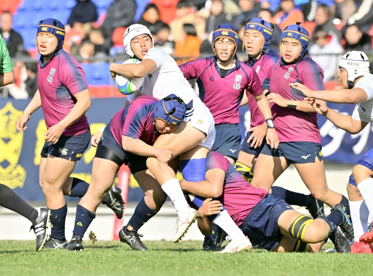 タックルを仕掛けて激しく競り合う国学栃木の選手ら＝５日午後１時25分、大阪府東大阪市の花園ラグビー場、広瀬華撮影