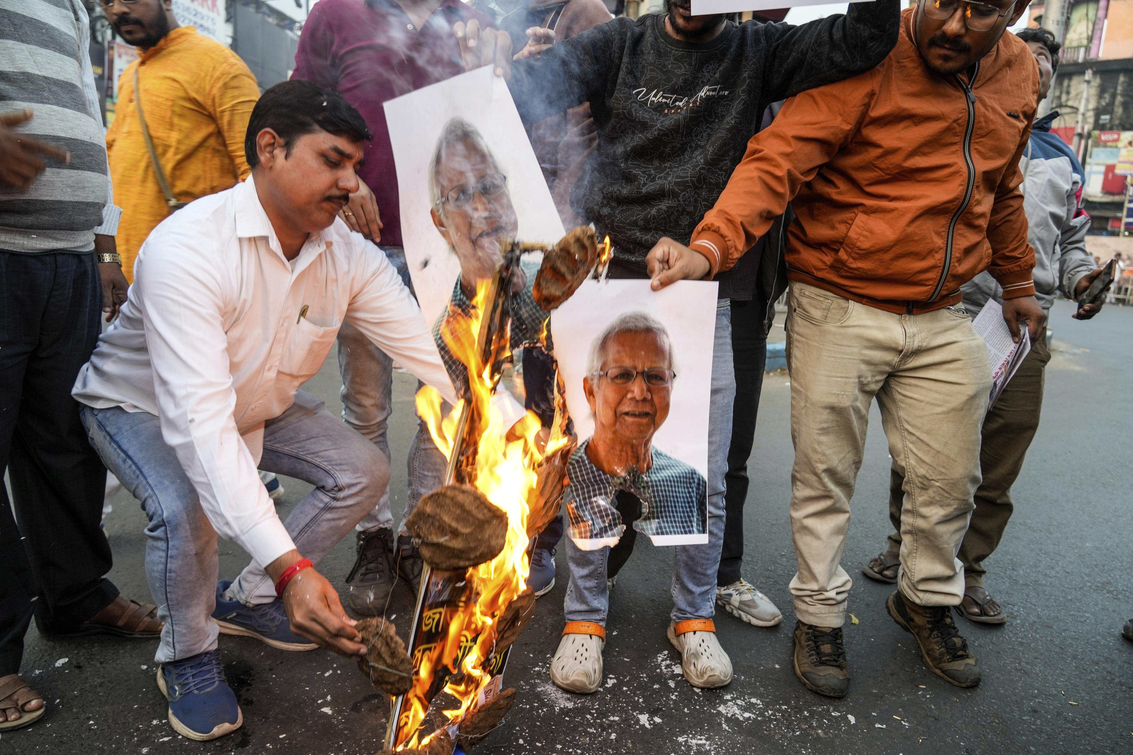 インド・コルカタで、バングラデシュ暫定政権のユヌス首席顧問の写真を燃やすヒンズー教団体の活動家＝2024年12月（AP＝共同）