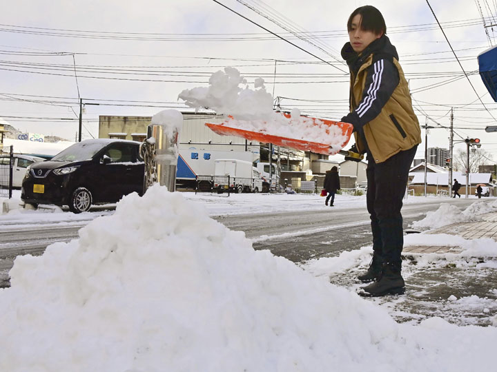 雪かきをする市民＝２３日午前８時１０分ごろ、福島市