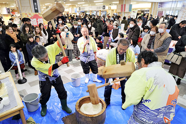 初売りの買い物客らが見守る中で行われた餅つき＝山形市・県観光物産会館ぐっと山形