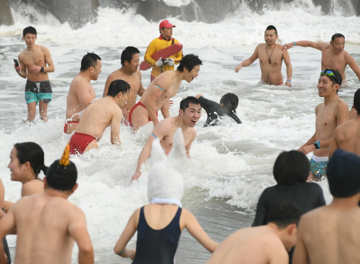 寒中水泳を楽しむ参加者ら＝１１日、米子市の皆生温泉海遊ビーチ