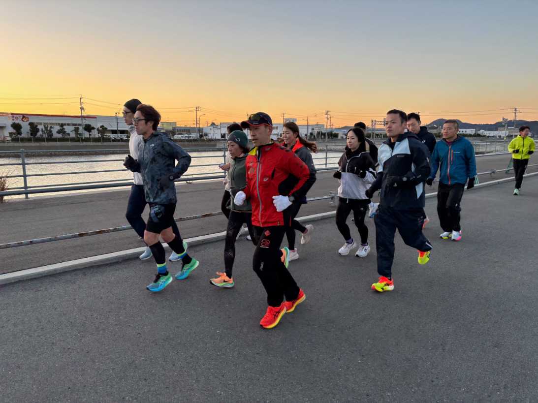 朝日が昇り始める中、全員でジョギングして体を温めます＝徳島市東沖洲