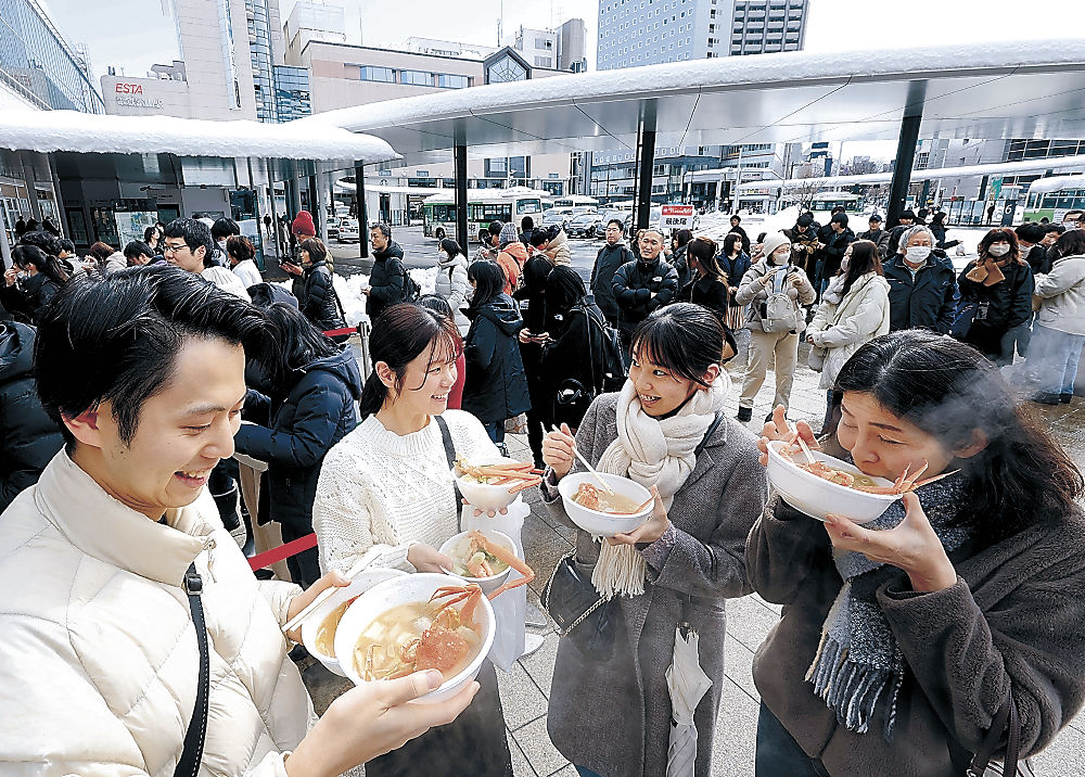 熱々の鍋料理に舌鼓を打つ来場者＝９日、富山駅