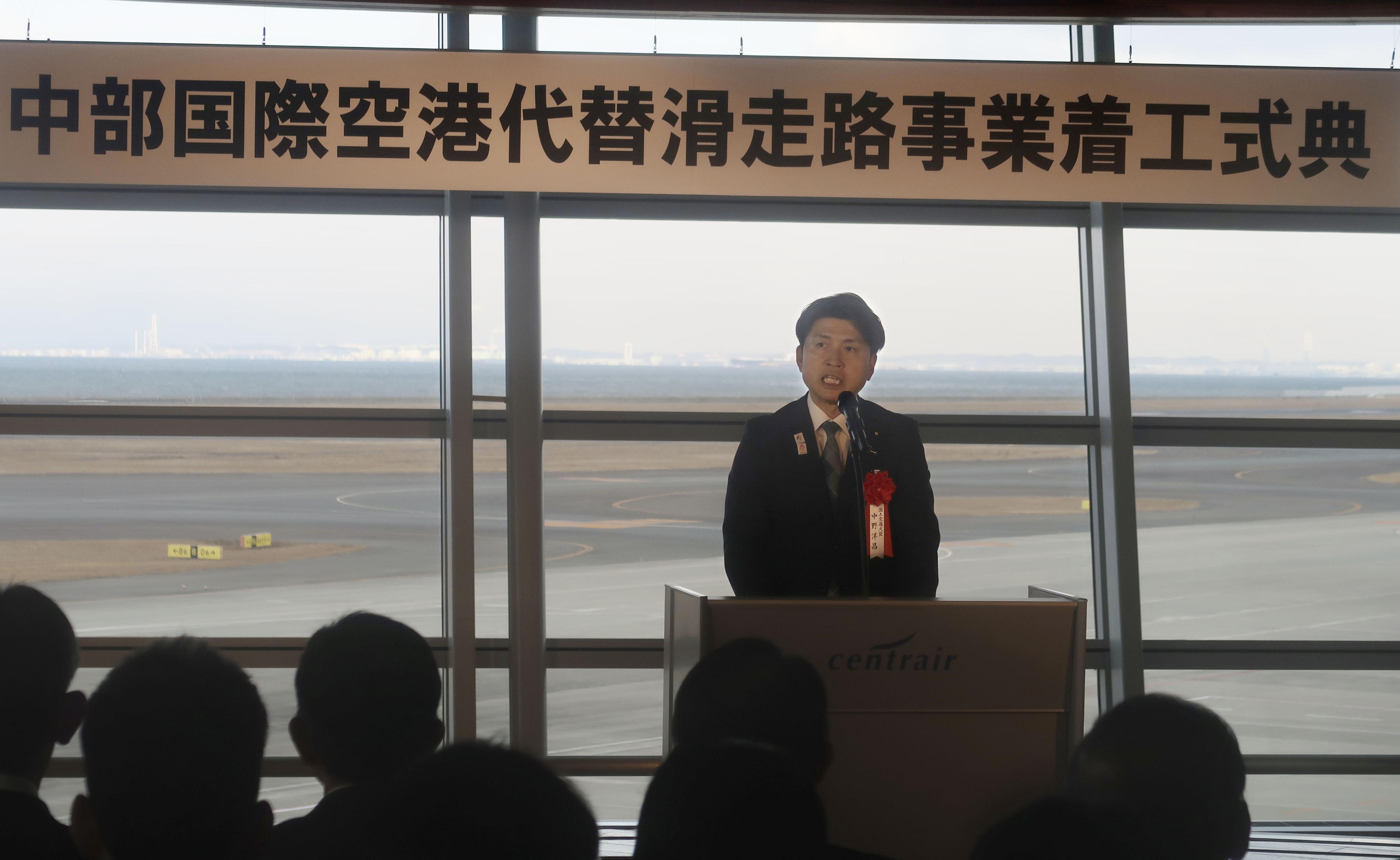 中部国際空港が代替滑走路の着工許可を受け開いた式典で、あいさつする中野洋昌国交相＝22日午前、愛知県常滑市