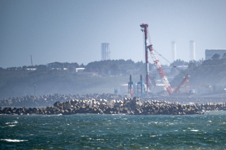 Mist hangs over the coast near the crippled Fukushima Daiichi Nuclear Power Plant (rear) of the Tokyo Electric Power Company (TEPCO), as seen from Ukedo fishing port in Namie, Fukushima prefecture on Aug. 24, 2023, the day the Japanese government began releasing treated wastewater from the plant into the Pacific Ocean, despite angry opposition from local fishermen and China.