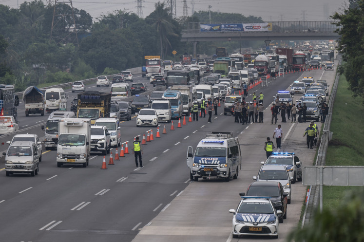 Police investigate on April 9, 2024 the scene of a fatal car crash involving two cars and a bus at Kilometer Marker 58 of the Jakarta-Cikampek toll road in Karawang, West Java, which killed 12 and injured two people.