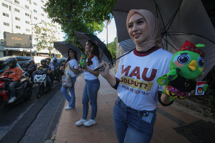 A model displays Si Jali, the mascot for the 2024 East Java gubernatorial election, to motorists in Surabaya, East Java, on Sept. 6, 2024 as a move to persuade voters to cast their votes in the upcoming regional election, slated for Nov. 27.