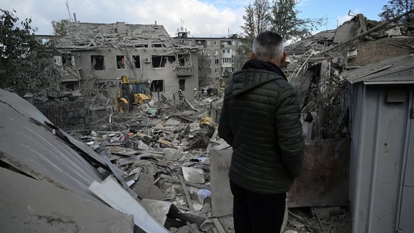 A resident watches rescuers clearing debris after Russian missile strikes in Dnipro, eastern Ukraine on 26 October