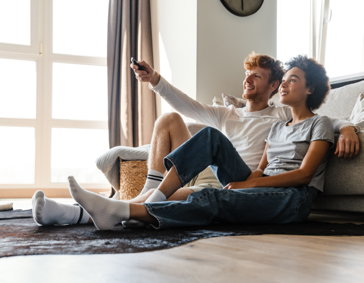 Two individuals seated on a couch, sharing a positive customer testimonial about their experience.