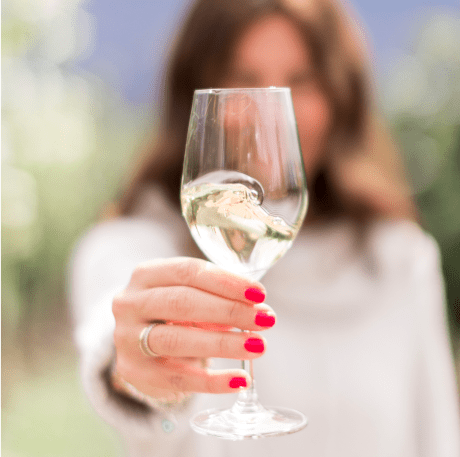 Jillian Harris Holding up a glass of white wine.