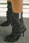 Close up side view of the slouchy, pull on ink luxe knit Leg Warmers that can be worn pulled up on scrunched down