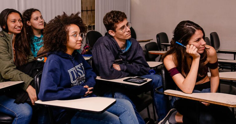 estudantes brancos e negros em uma sala de aula de faculdade