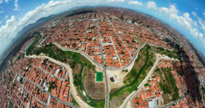 imagem aérea do rio Maranguapinho, no estado do Ceará; ao redor, casas do bairro de Vicente Pinzon