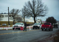 On days when the state executes an inmate, barricades block access to the Oklahoma State Penitentiary in McAlester. A guard is seen walking near one of the barricades a few hours before the state executed Gilbert Postelle on Feb. 17, 2022. (Whitney Bryen/Oklahoma Watch)