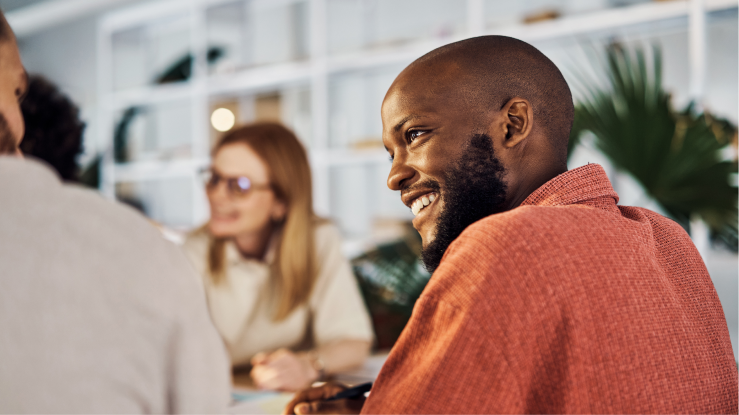 Smiling coworkers sitting together at a table. 