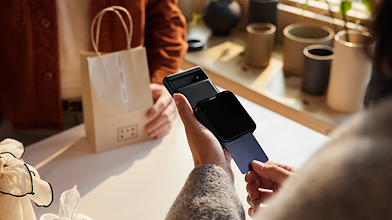 La proprietaria di un negozio che elabora l'acquisto di un cliente usando un terminale portatile per carte di credito collegato a un dispositivo mobile Pixel.