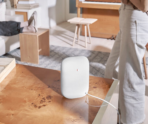 A Nest Audio speaker on a table in a living room