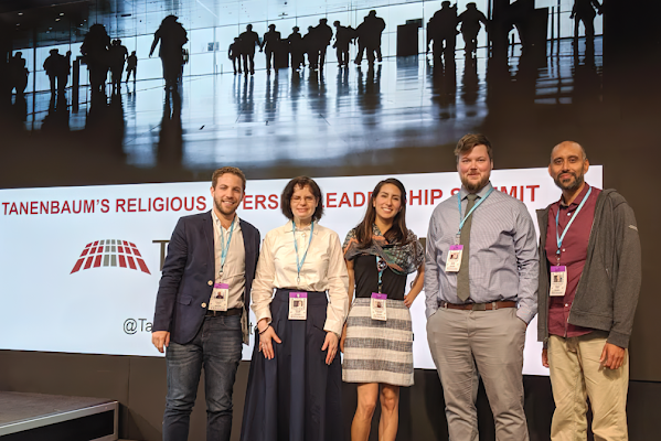 Five Googlers stand together at a conference