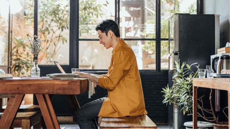 Personne assise à un bureau, travaillant sur un ordinateur portable 