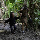 Una niña migrante venezolana es ayudada por su madre cuando llegan a la aldea de Canaán Membrillo, el primer control fronterizo de la provincia de Darién en Panamá.