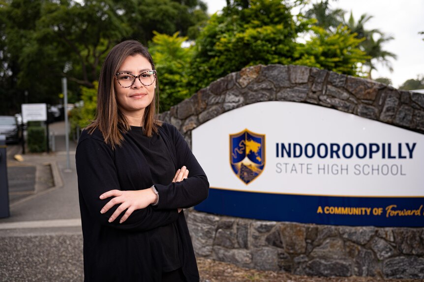 A woman next to a school sign