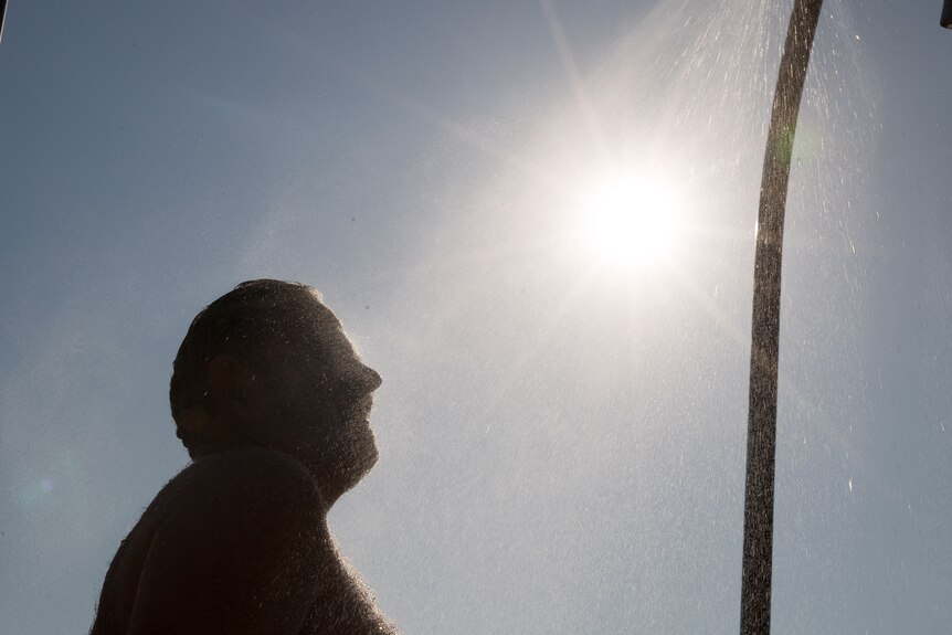 A man stands in front of the bright sun.