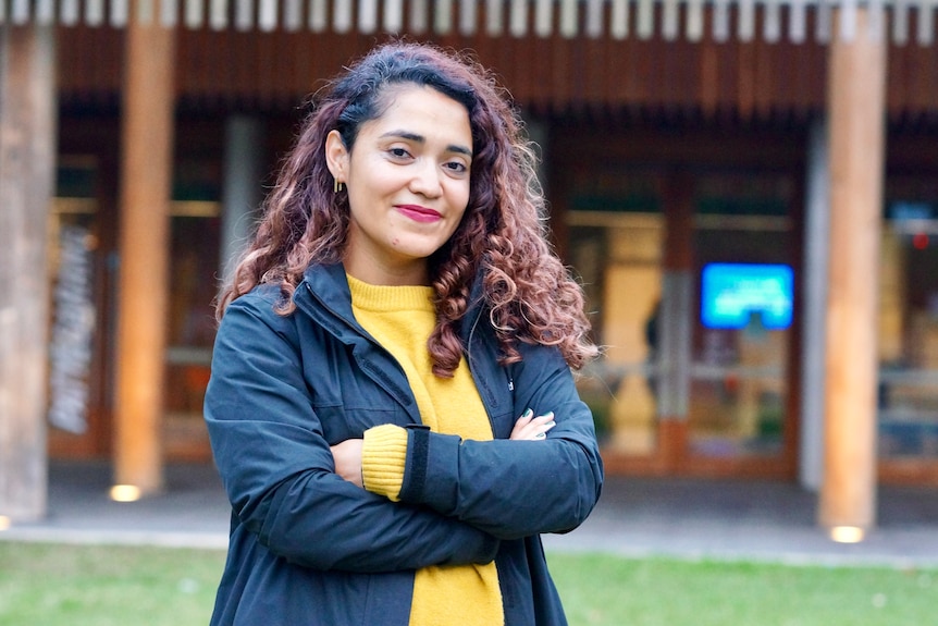 Diana Olmos stands with her arms crossed.