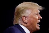 Donald Trump shot in profile, with his mouth open as he speaks 