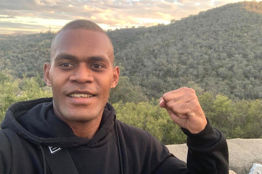 Boxer Lemuel Silisia posing by a mountain 