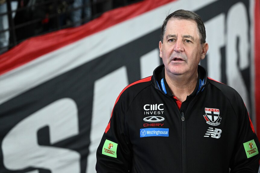 A picture of St Kilda AFL coach Ross Lyon standing on the sidelines at Docklands looking out on the field during a match.