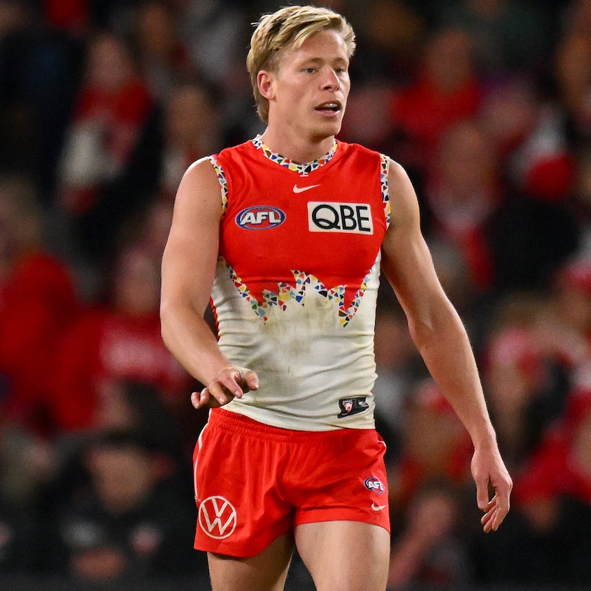 Isaac Heeney walking along the Docklands pitch during an AFL match.